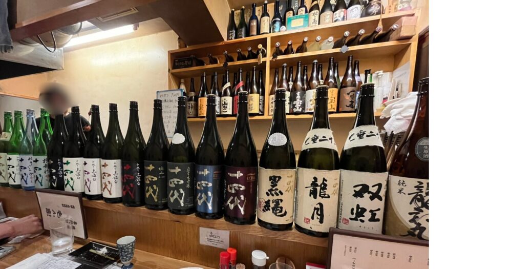 巣鴨 もん家のカウンターに並ぶ日本酒と十四代