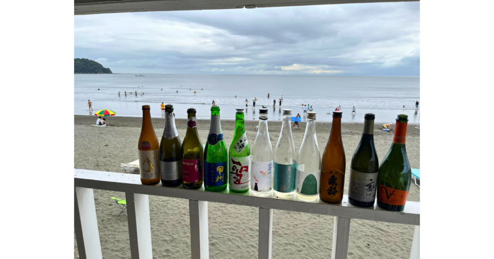 江の島の海を背景に並べた海の家で飲んだ日本酒の空き瓶