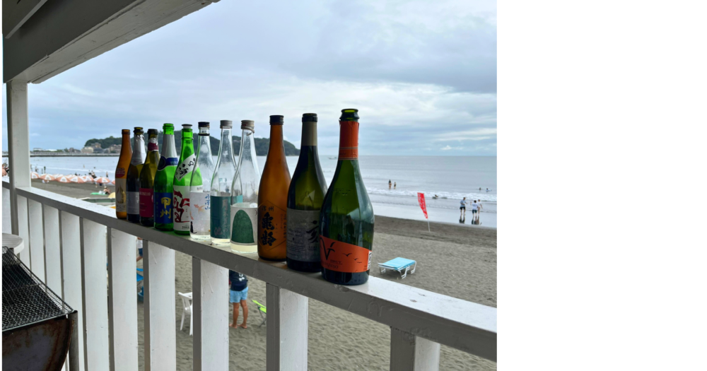 江の島の海を背景に並べた飲んだ日本酒の空き瓶